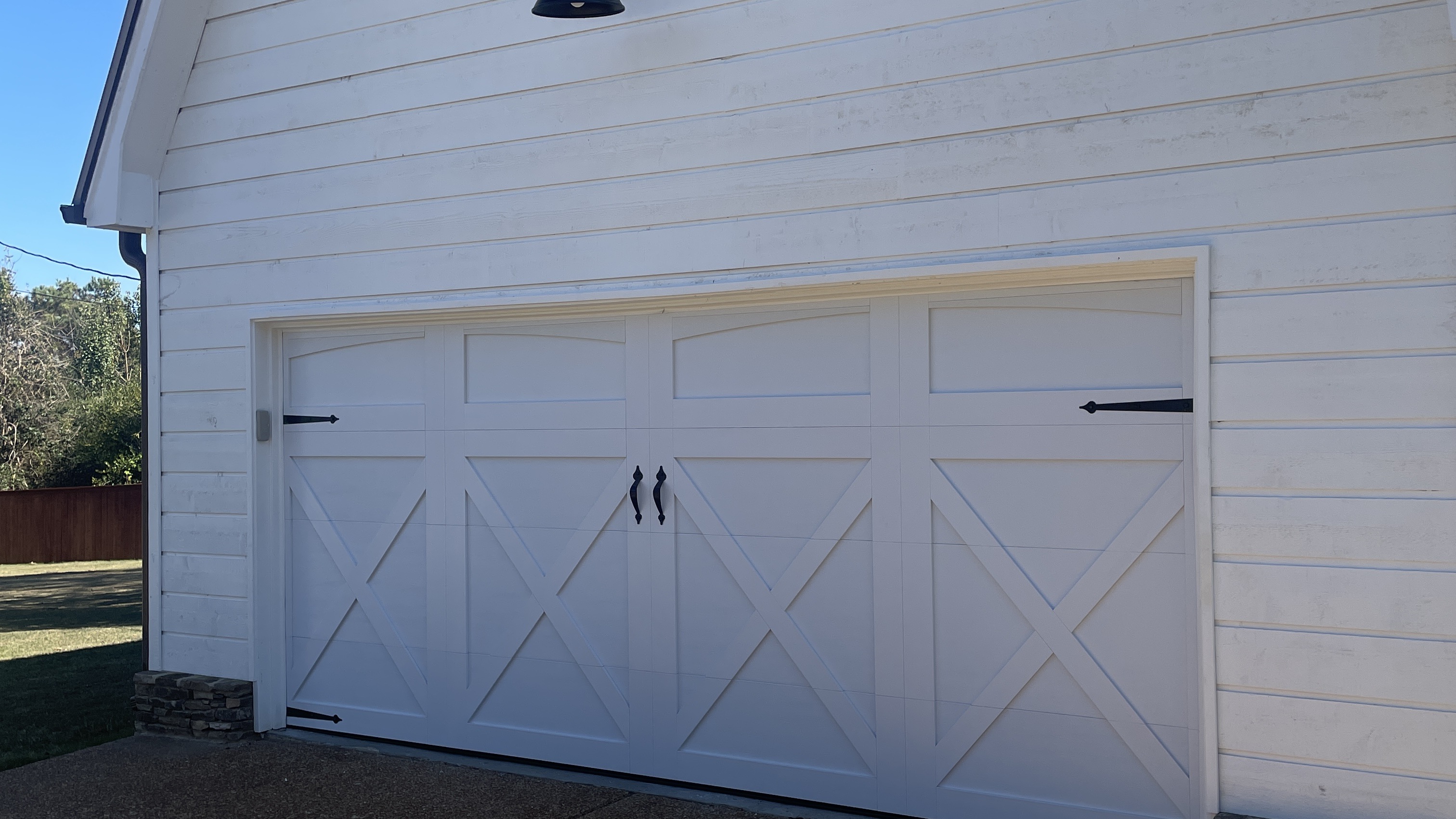 Finished white carriage-style garage door on a white home in Greater Memphis