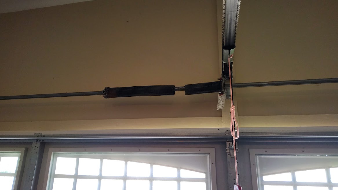 Broken torsion spring above a garage door before repair by Lift Doctors