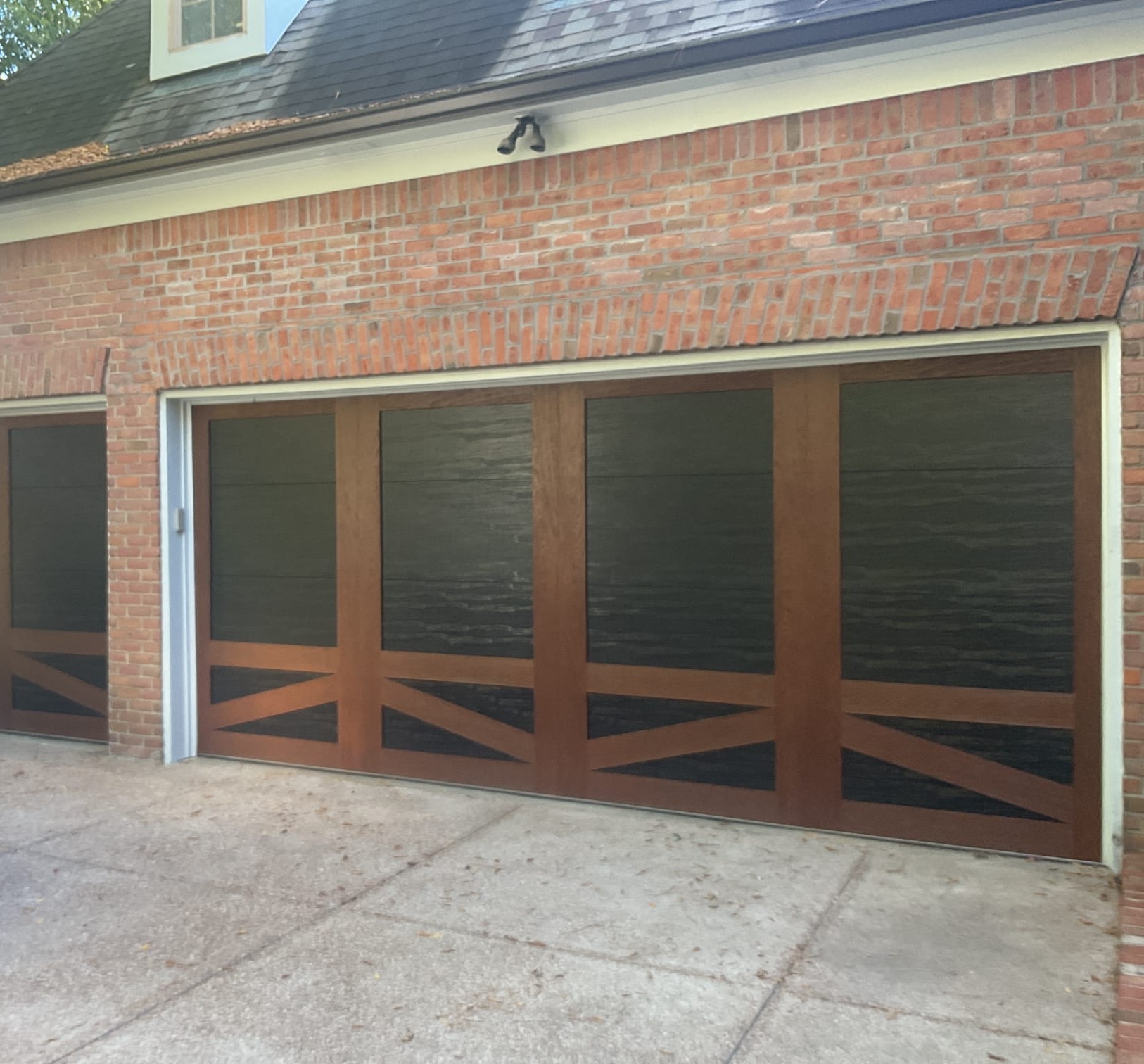 Finished custom wood-look carriage garage doors with dark inset panels