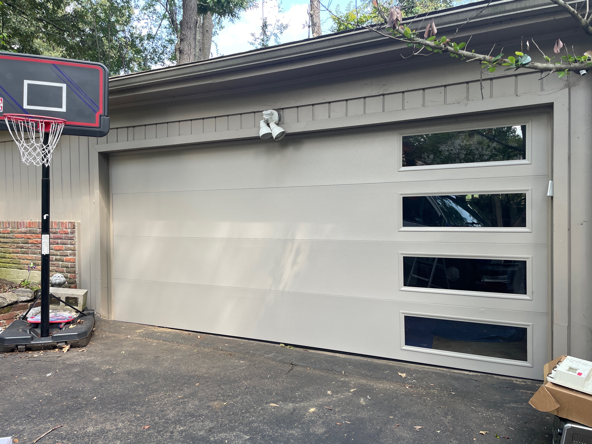 After view of a modern light gray garage door with horizontal windows installed by Lift Doctors