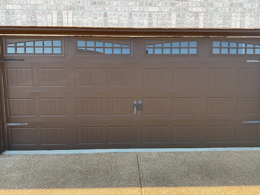 Finished brown carriage-style garage door with window panels in Greater Memphis